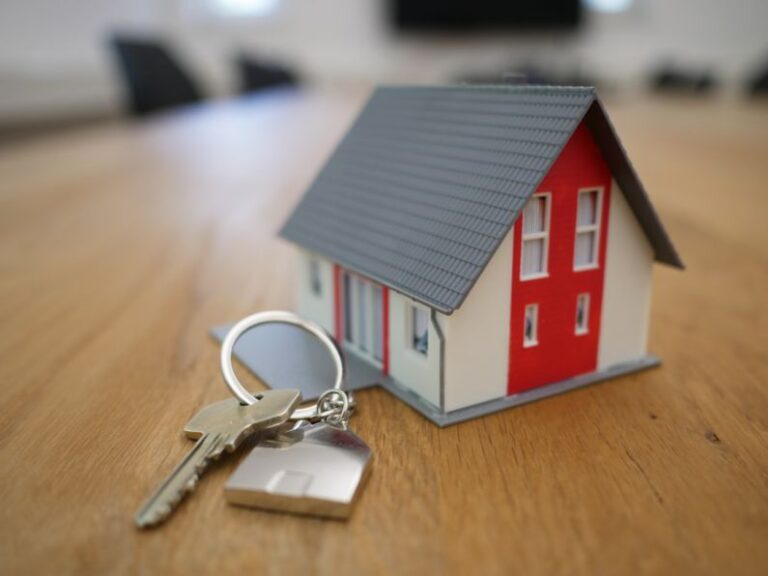 Mortgage - white and red wooden house miniature on brown table
